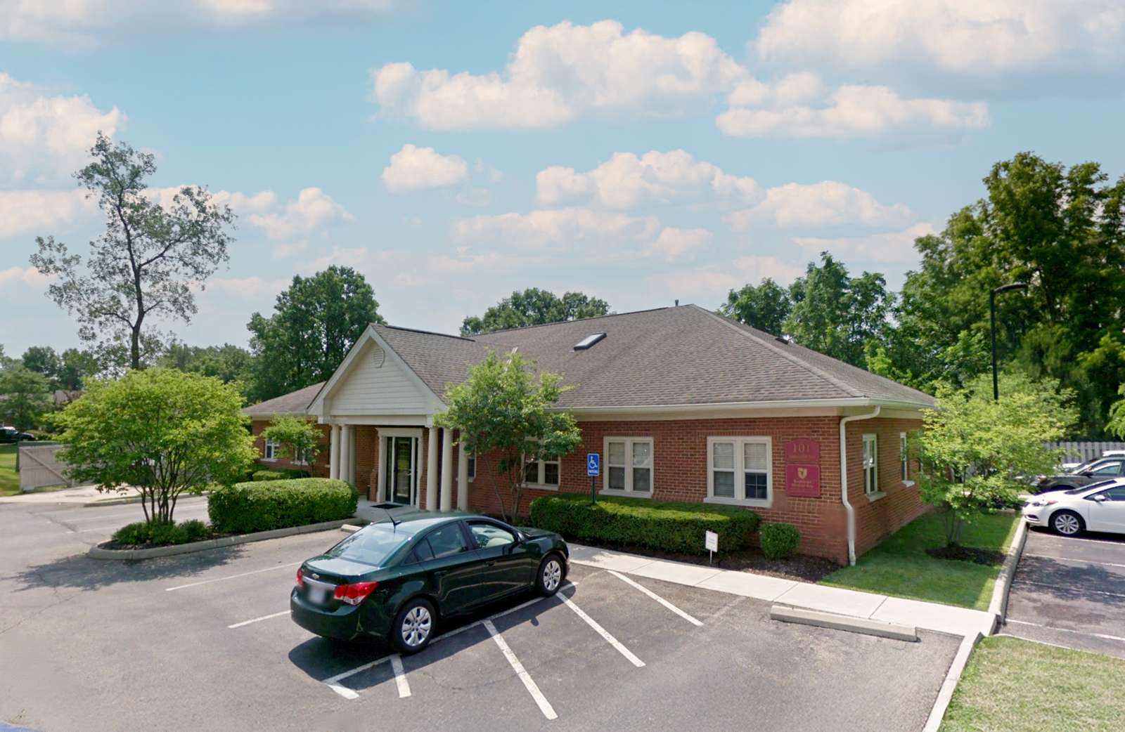 Brick commercial building with covered entrance and parked car at 101 Commerce Park Drive.