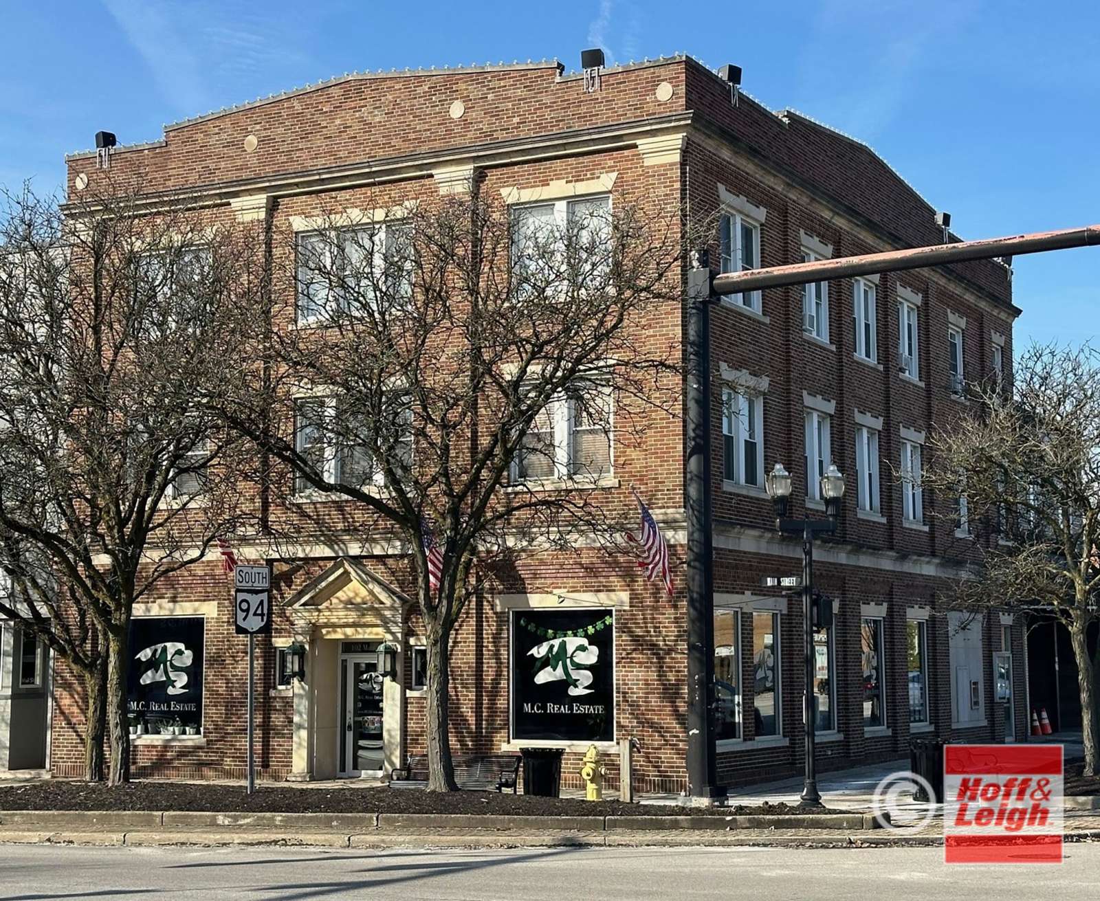 Historic brick building at 102 Main Street with ground-floor storefronts and residential upper floors.