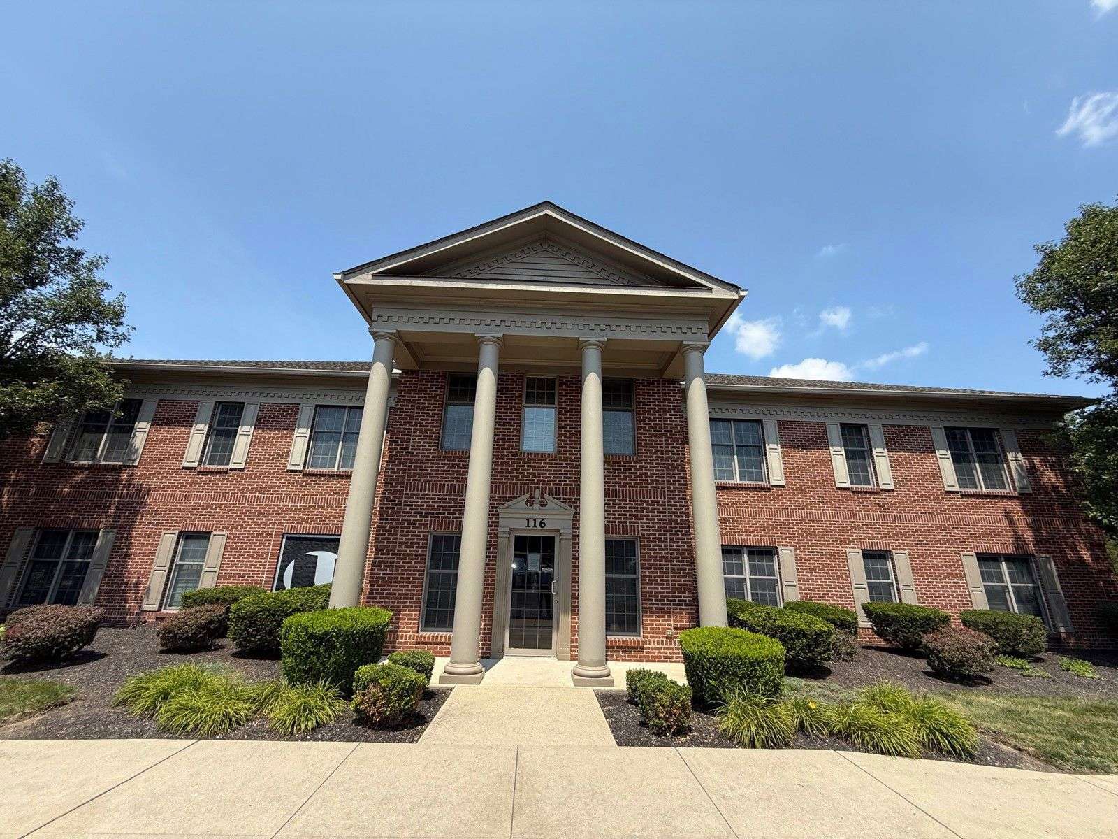 Brick institutional building with white columns and a triangular pediment at 116 County Line Road West.