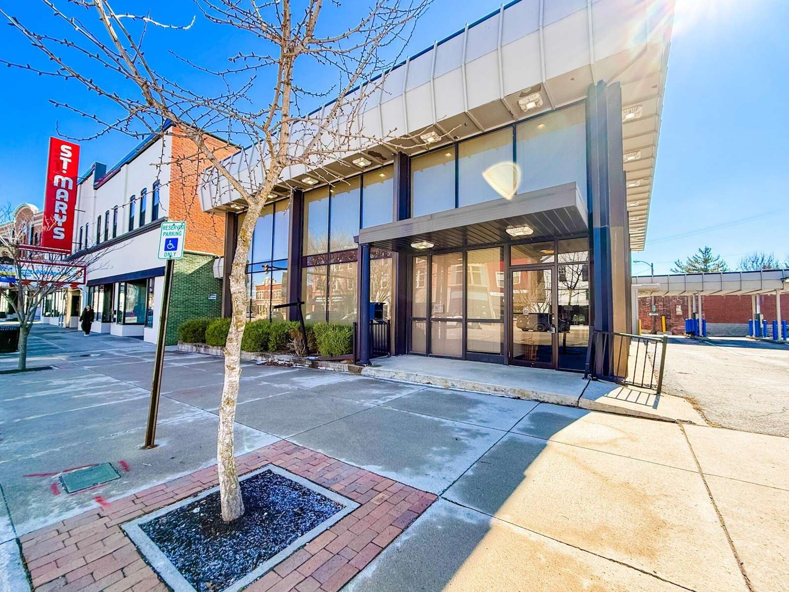 Modern storefront with large windows at 125 W Spring Street, featuring brick paving and bare trees along the entrance.