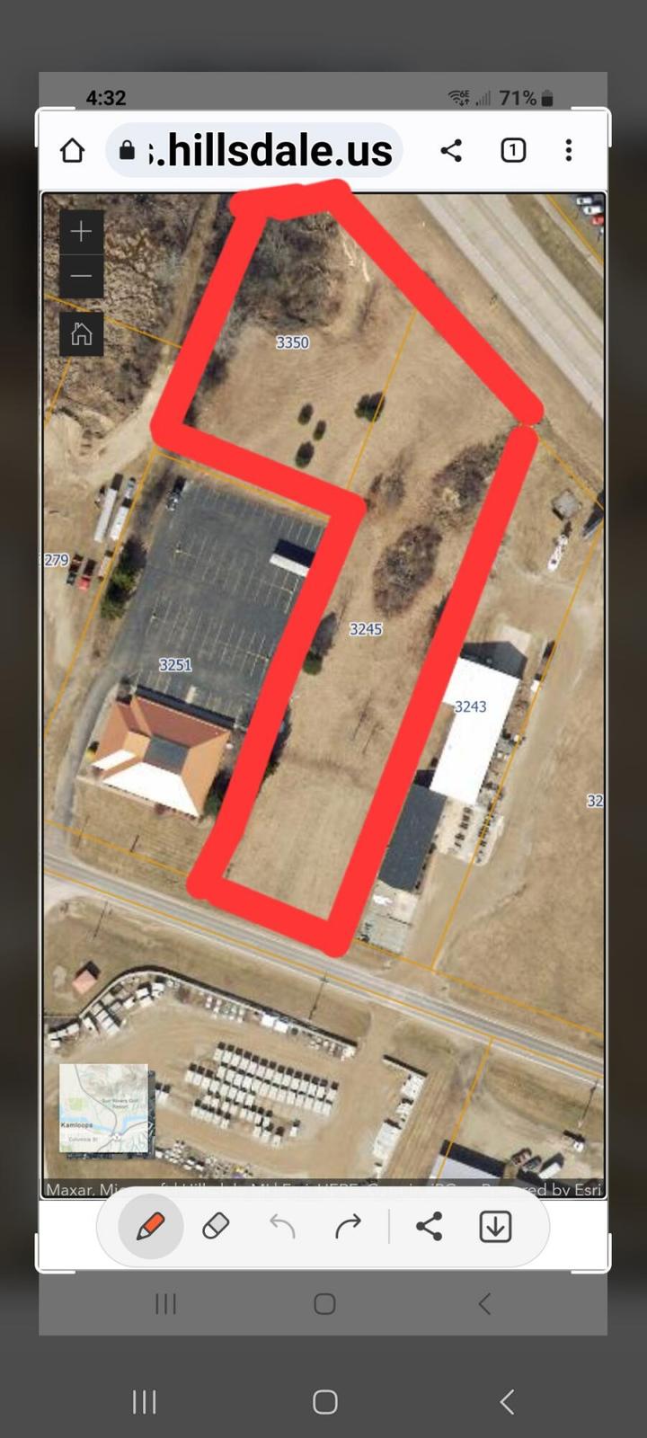Aerial view of a property outlined in red showing buildings and parking areas on hillsdale.us website.