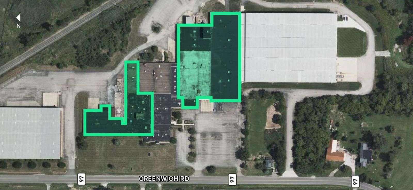 Aerial view of 286 West Greenwich Road showing building footprint highlighted in green overlay with parking areas and surrounding landscape.