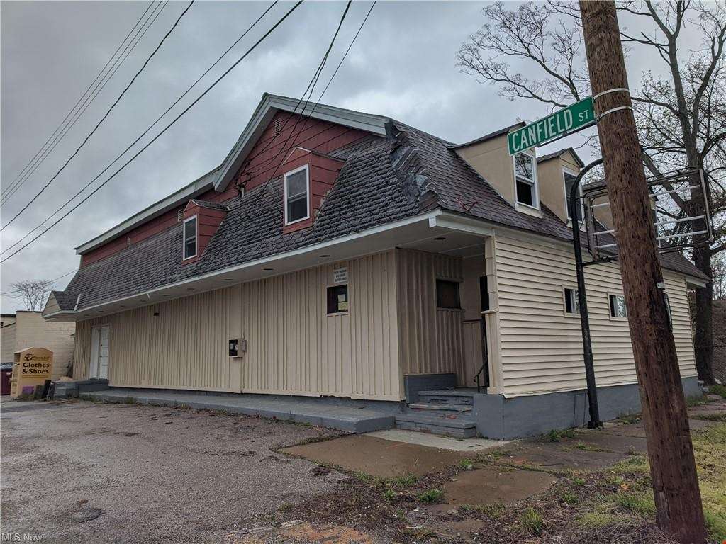 Two-story house at 367 N State St in Painesville, OH with red brick upper level and tan siding lower level.
