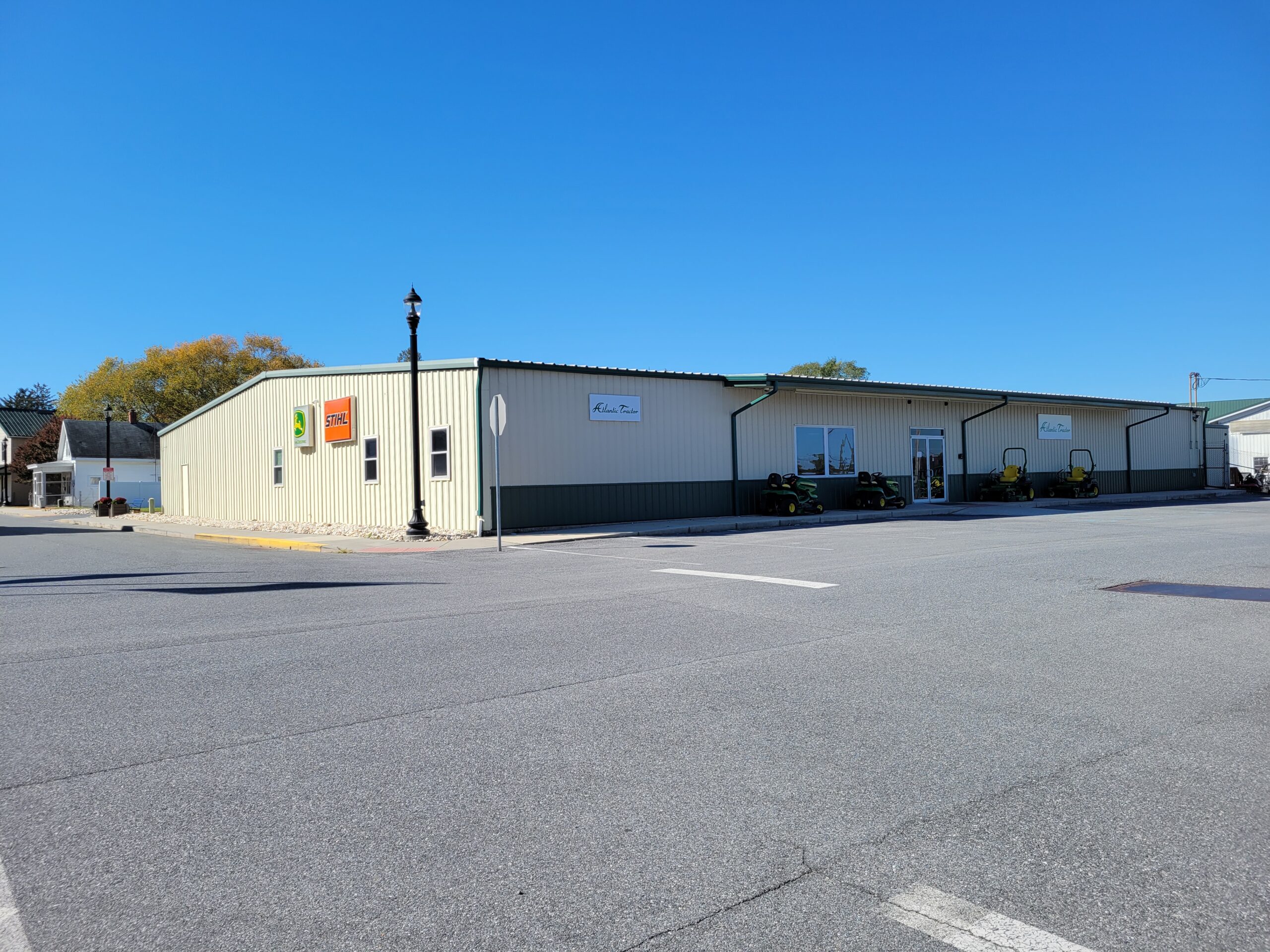 Modern commercial building with tan and dark metal siding under clear blue sky in daytime.