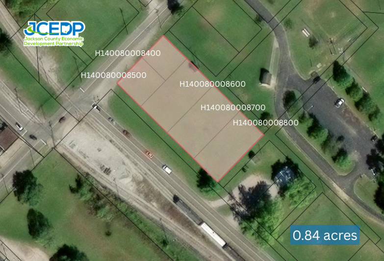 Aerial view of a 0.84-acre property with multiple parcel identifiers marked in tan and green sections along a road.