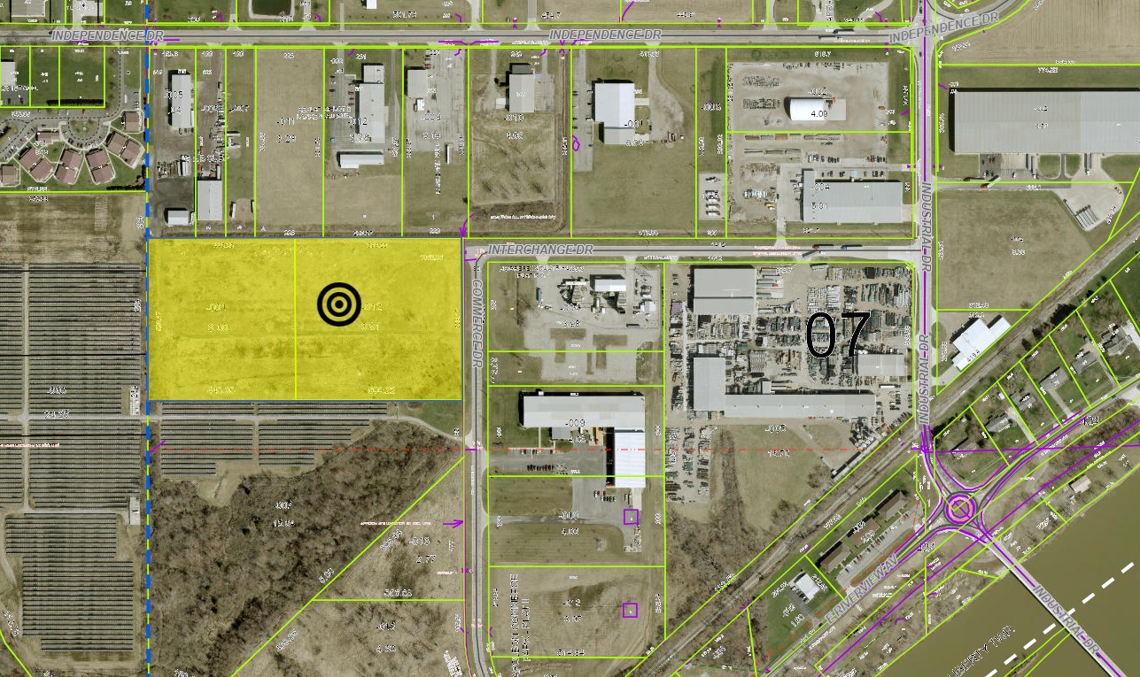 Aerial map view of industrial area with highlighted yellow parcel and target marker among surrounding buildings and roads.