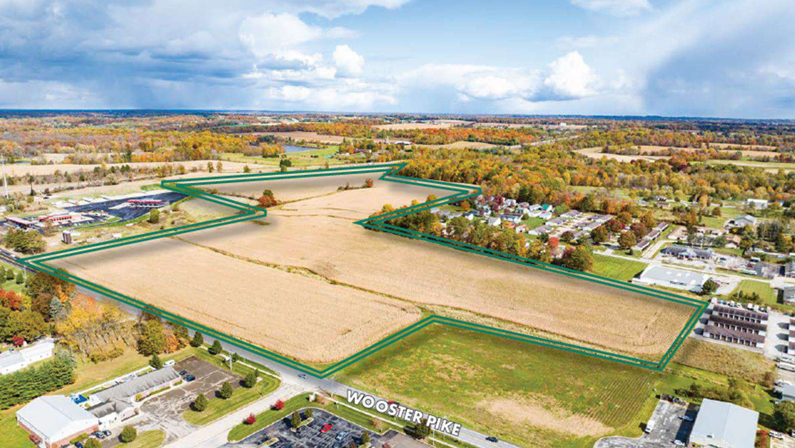 Aerial view of a large vacant property along Wooster Pike with green boundary lines and surrounding commercial and residential development.