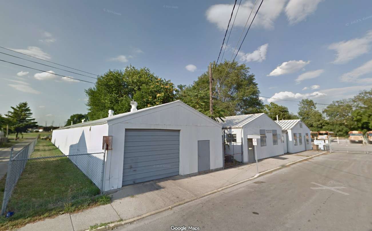 White commercial garage and storage buildings on Chestnut Street with paved driveway and blue sky.