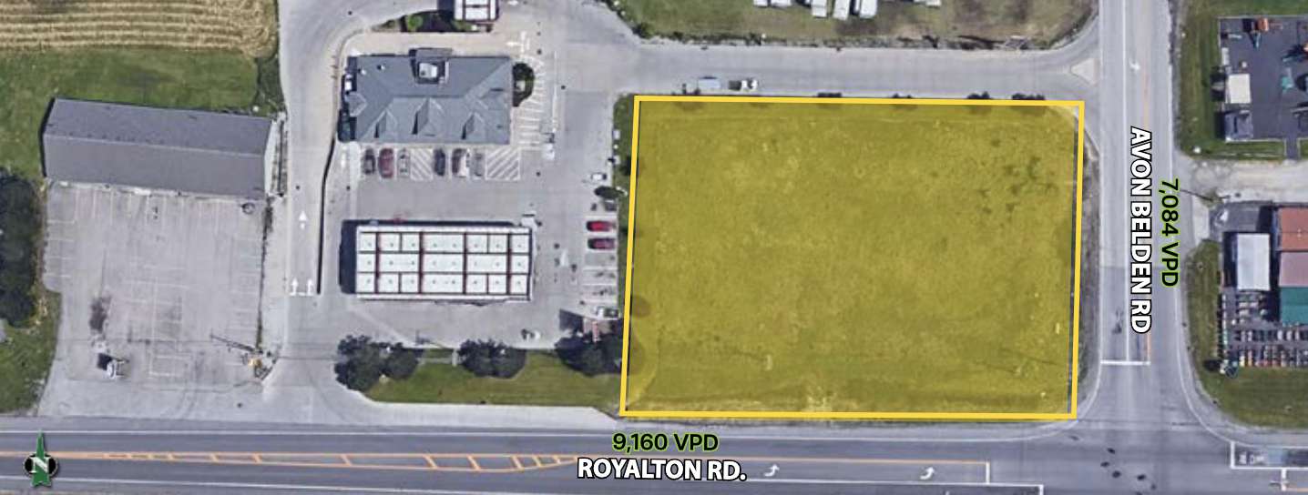 Aerial view of a vacant 1/4-acre corner lot with yellow boundary line along a street.